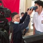 Petugas Disdukcapil melakukan perekaman biometrik terhadap seorang pelajar dalam pelayanan jemput bola KTP elektronik di sekolah. Program ini memudahkan pelajar melakukan perekaman tanpa harus datang ke kantor Disdukcapil.