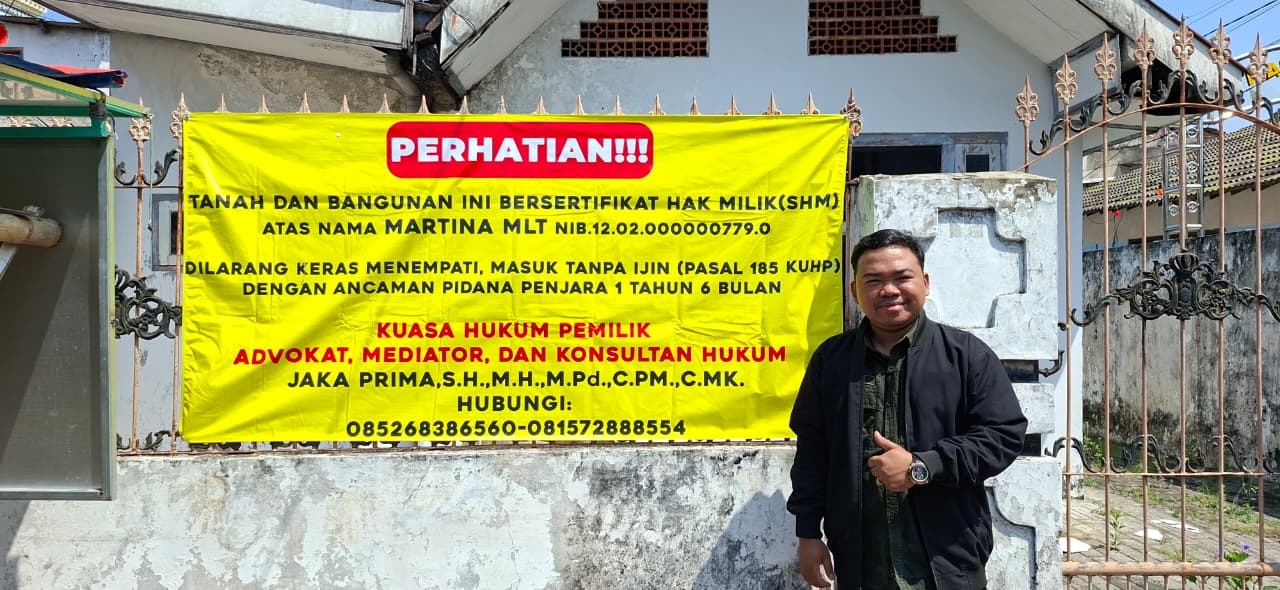 Advokat Jaka Prima berfoto di depan rumah yang menjadi objek sengketa di Kota Mojokerto.