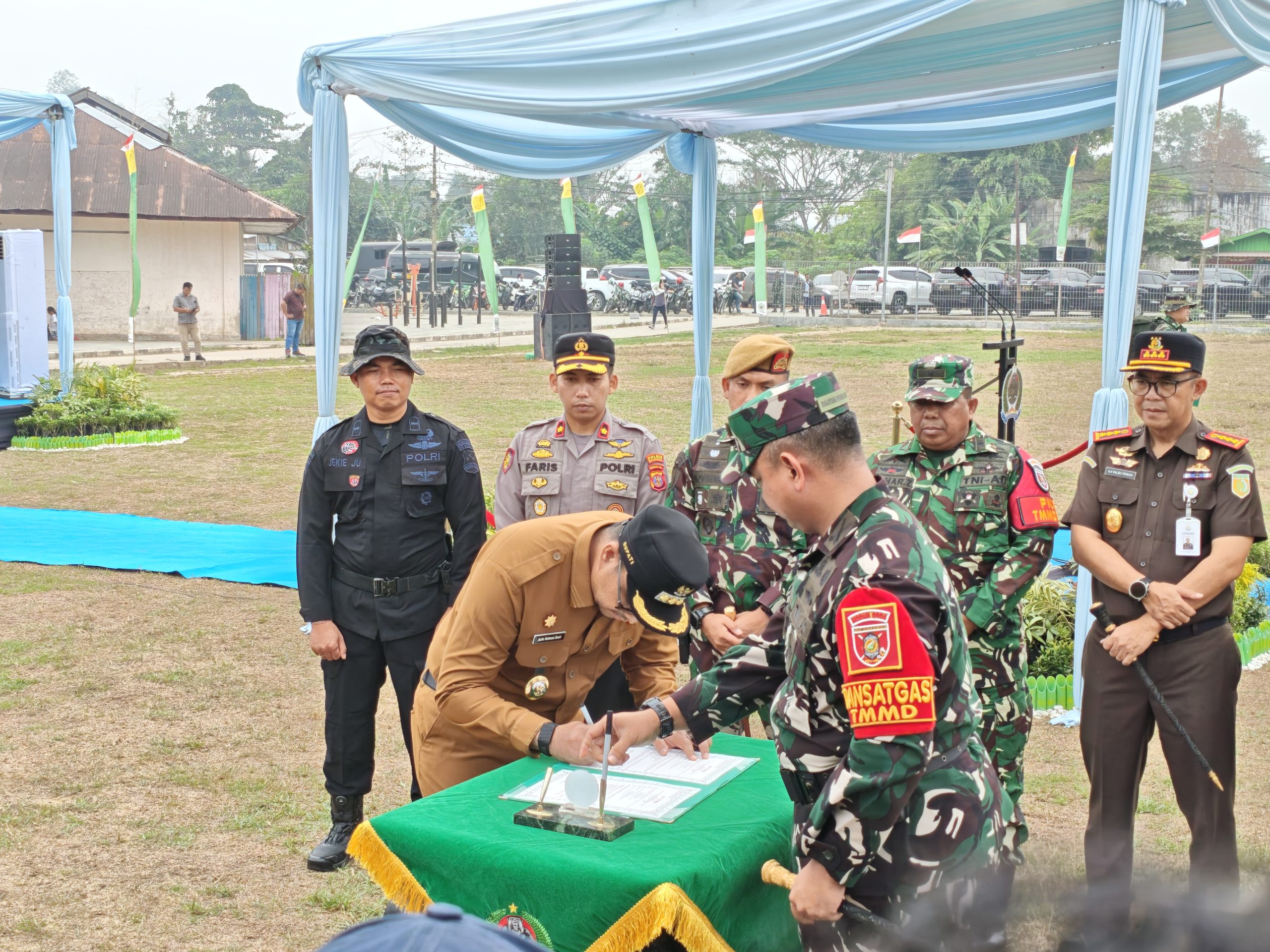 Bupati Kutai Kartanegara (Kukar) Aulia Rahman Basri menandatangani dokumen pelaksanaan program TNI Manunggal Membangun Desa (TMMD) ke-130 Kodim 0906/Kukar, disaksikan jajaran TNI, Polri, dan unsur terkait saat pembukaan kegiatan di Lapangan Bola Loa Kulu Kota, Kecamatan Loa Kulu, Selasa (13/10/2026).